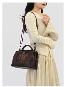 Close-up of vintage embossed leather handbag featuring exquisite floral patterns and metal lock