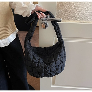 Vue détaillée du sac matelassé noir brillant avec fermeture éclair argentée suspendue