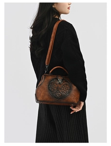 Detail of vintage embossed leather handbag with bronze lock and doctor bag frame
