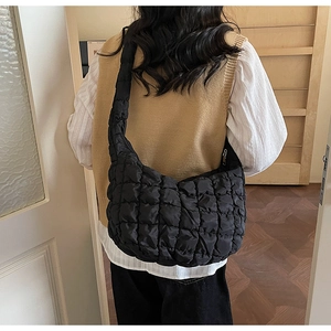 Gros plan du sac nuage noir matelassé avec texture quadrillée et détail de fermeture argentée