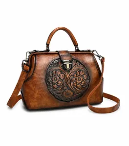 Detail view of vintage brown leather handbag featuring floral embossing and metal clasp