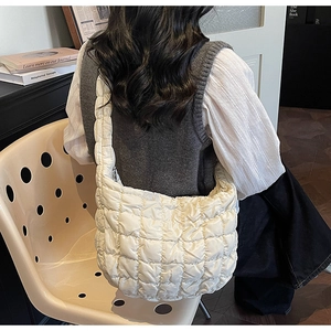 Détail d'un sac bouffant matelassé blanc avec texture douce dans un décor quotidien