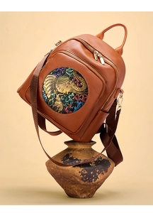 Detail of soft leather backpack with embossed elephant pattern on warm background