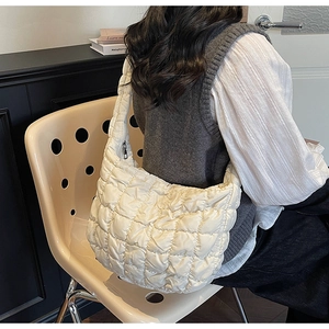 Sac fourre-tout blanc matelassé porté par un mannequin, texture rembourrée et style coréen
