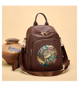 Detail of vintage brown leather backpack with colorful elephant relief and golden zipper