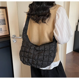 Sac nuage matelassé noir au design demi-lune porté à l'épaule pour un style chic et moderne