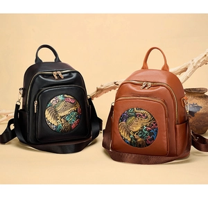 Detailed view of leather backpacks with ethnic elephant embossing in black and brown