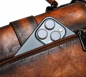 Detail of vintage brown leather bag with a secure back zipper pocket holding a smartphone