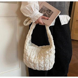 Détail du sac bulle matelassé blanc montrant la texture douce et la bandoulière
