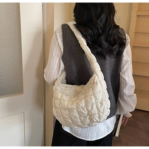 Détail du sac à bulles matelassé blanc porté par un modèle montrant la texture
