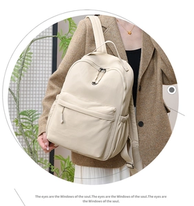 Close-up of minimalist cream white nylon backpack with multi-pocket storage design