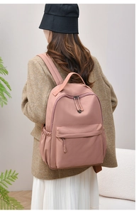 Detailed back view of a dusty pink waterproof nylon backpack with adjustable straps