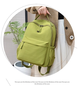Detail of water-resistant green nylon backpack with wide top handle and zipper pocket