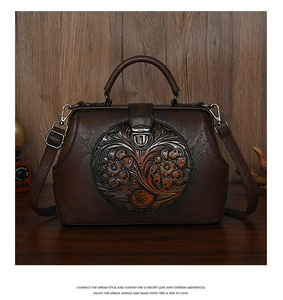 Detail of vintage embossed floral pattern on brown leather satchel with handle