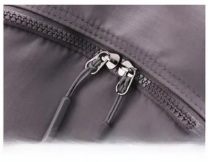 Detail of durable dual zippers and water-resistant nylon texture on the grey backpack