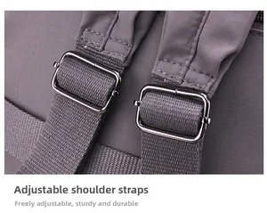 Detail of adjustable strap with metal buckle and reinforced stitching on gray backpack