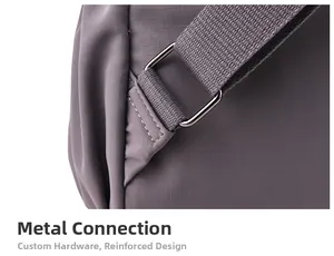 Detail of grey nylon backpack showing ripstop texture, reinforced stitching, and metal buckle