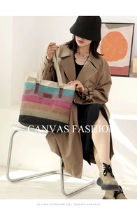 Detailed view of the multi-color striped canvas tote bag texture with leather handle accents