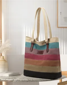 Detail of striped canvas tote bag showing the textured fabric and premium leather logo patch
