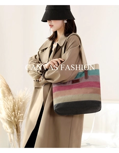 Close-up of canvas tote bag with colorful striped patterns and leather handles