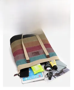Detail showing high-capacity striped canvas tote bag holding a tablet and daily items