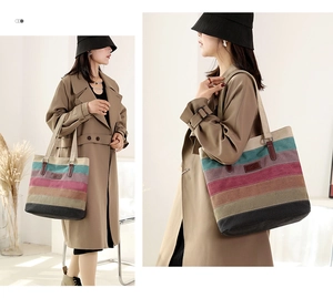 Detailed close-up of multi-color striped canvas tote bag with brown leather handles
