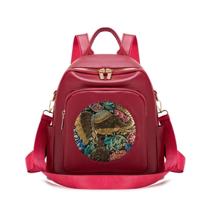 Burgundy faux leather backpack for women featuring ethnic elephant embossed pattern