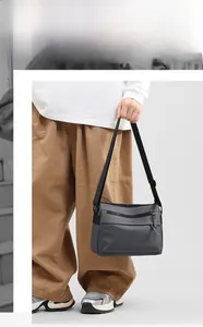 Close-up of waterproof grey messenger bag with layered zippers and adjustable strap