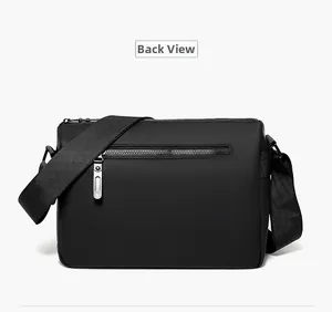 Back view of waterproof black messenger bag showing zipper pocket and nylon strap
