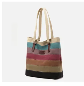 Close-up of striped canvas tote bag with leather logo tag and reinforced straps