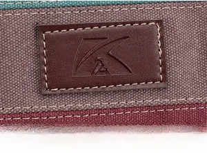 Detail of stitched K2 leather logo on multi-color striped canvas tote bag surface