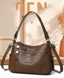 Close-up of brown litchi leather handbag with heart charms and multi-pocket design