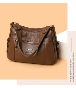 Detail of brown litchi grain texture on crossbody bag with metal kangaroo logo