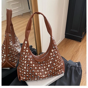 Detail of brown leather hobo bag with silver studs and crescent shape design