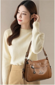 Detailed view of brown lychee grain leather handbag with multi-zippered compartments