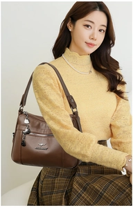 Macro detail of dark brown litchi pattern leather bag with silver kangaroo metal logo