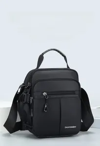 Detail of waterproof nylon shoulder bag featuring multi-pocket design and smooth zippers