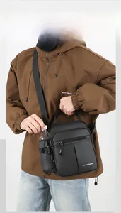 Detail of black oxford shoulder bag featuring a dedicated side pocket for water bottles