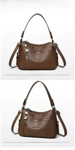 Detail of soft brown pebble leather handbag with multiple zippers and metallic hardware