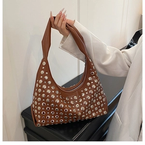Detailed shot of brown leather hobo bag featuring decorative silver metal rivets