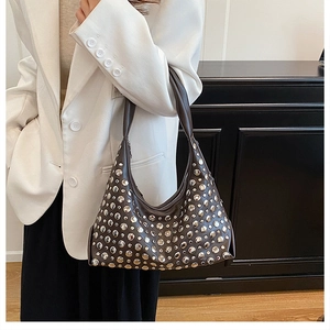 Detail of dark brown hobo shoulder bag with silver rivet studs on matte leather finish