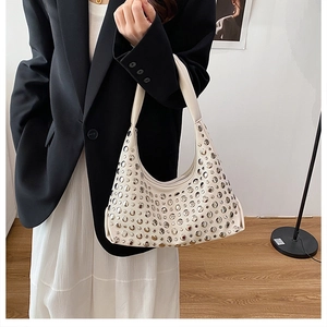 Detail of creamy white hobo bag with silver rivets and minimalist crescent shape design