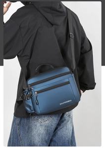 Close-up of waterproof navy blue crossbody bag with multi-zipper compartments on male model