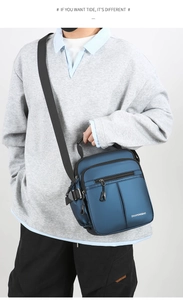 Detail view of a navy blue oxford fabric crossbody bag shown on a male model