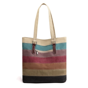 Striped canvas tote bag with multi-color patchwork and leather accents on white background