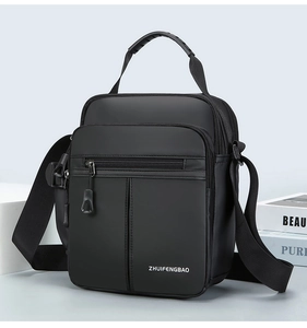 Close-up of a black oxford fabric crossbody bag with multi-pocket and reinforced handle