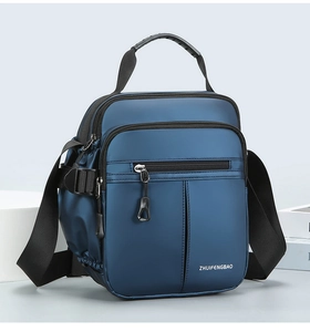Detail view of navy oxford fabric messenger bag with multiple functional zipper pockets