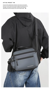Detail view of the gray waterproof crossbody bag with multiple zip compartments on a model