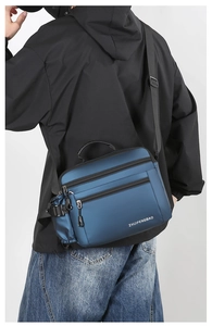 Detail view of water-resistant navy blue crossbody bag with multiple zippers and side pocket