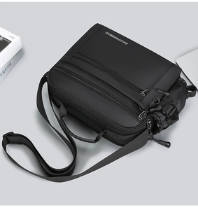 Detail of waterproof nylon shoulder bag showing triple-zipper compartments and side pocket